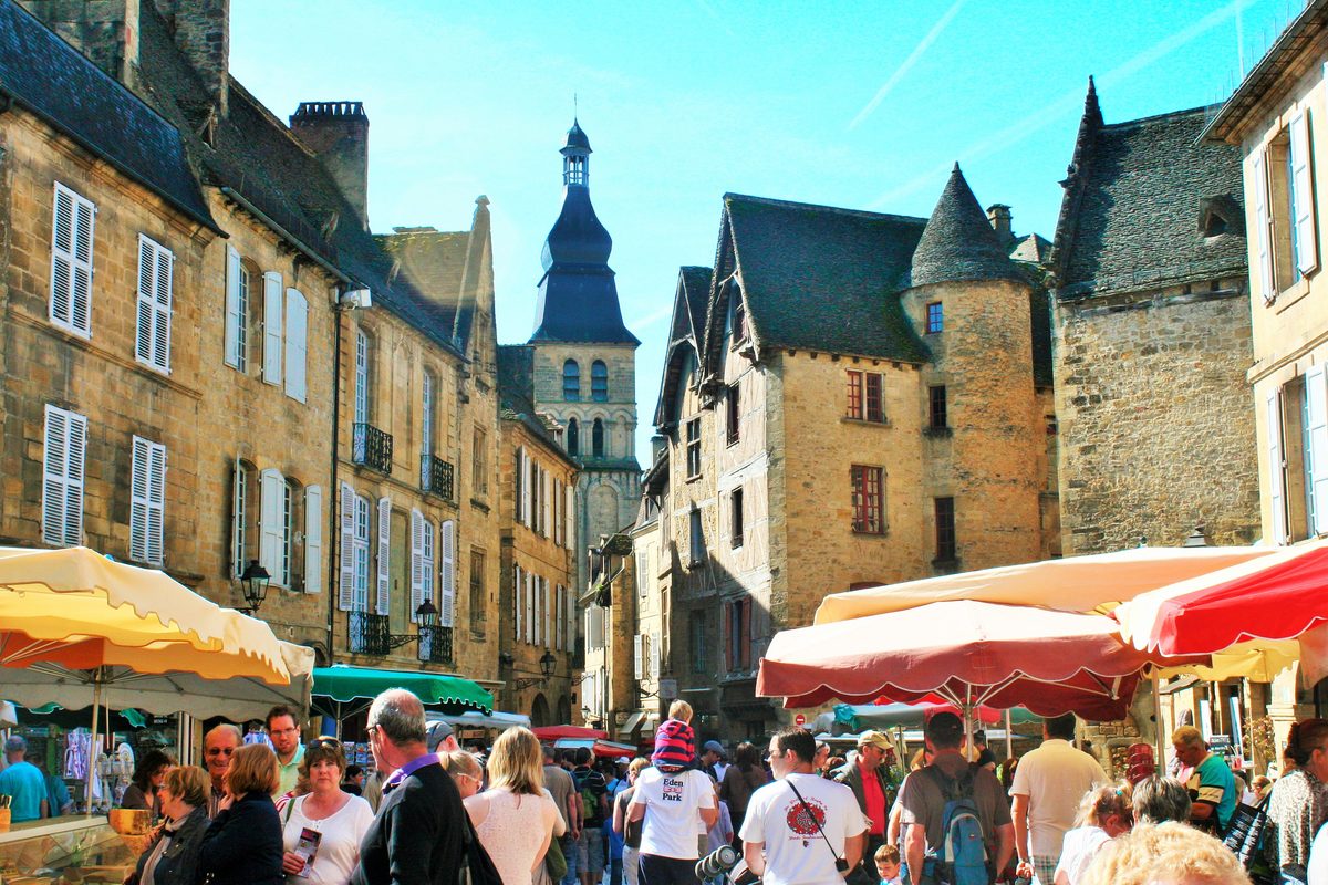 Le marché de Sarlat, place de la Liberté, entre les maisons de pierre blonde de la vieille ville