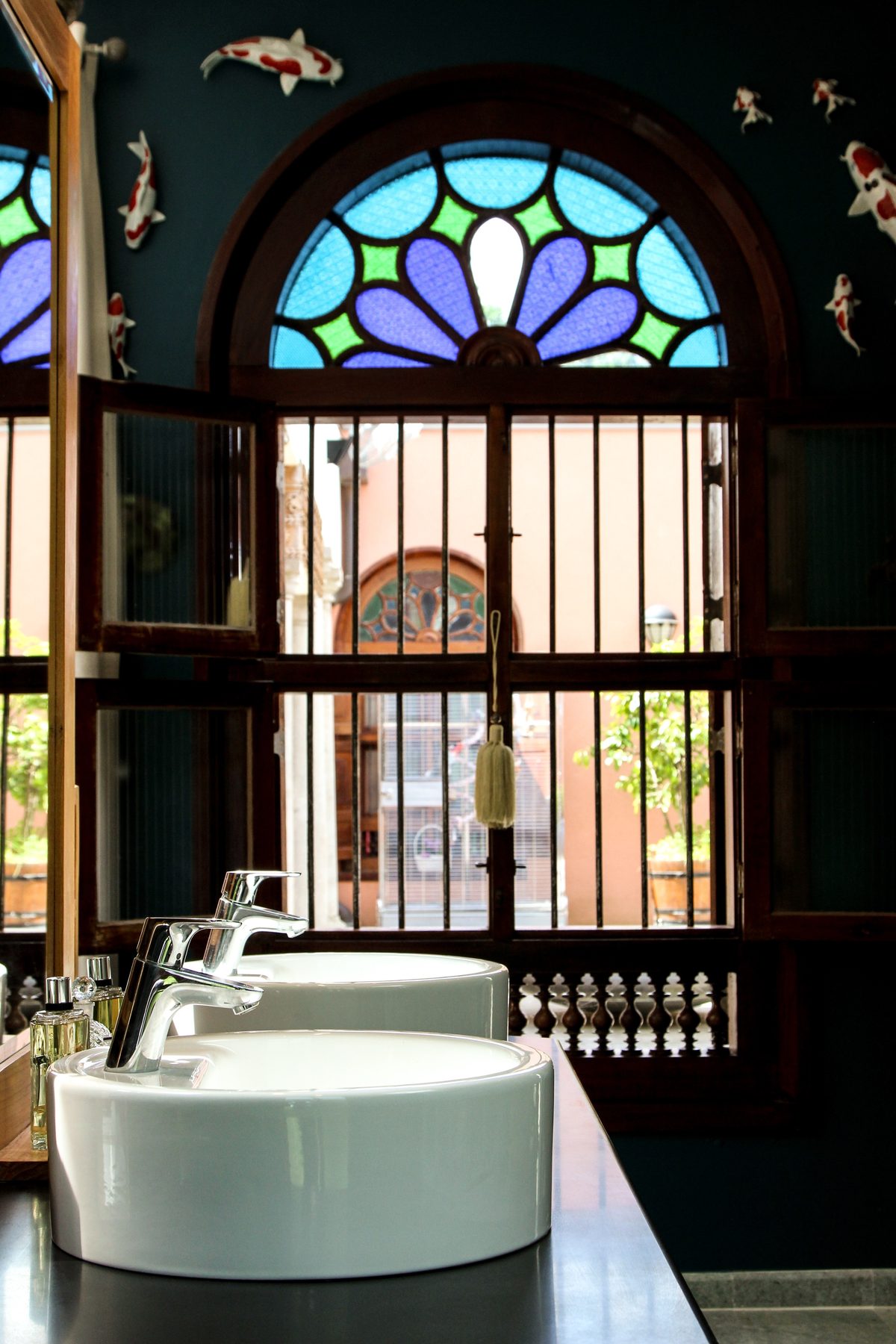 La salle de bains et son imposte de vitrail, ouverte sur le patio