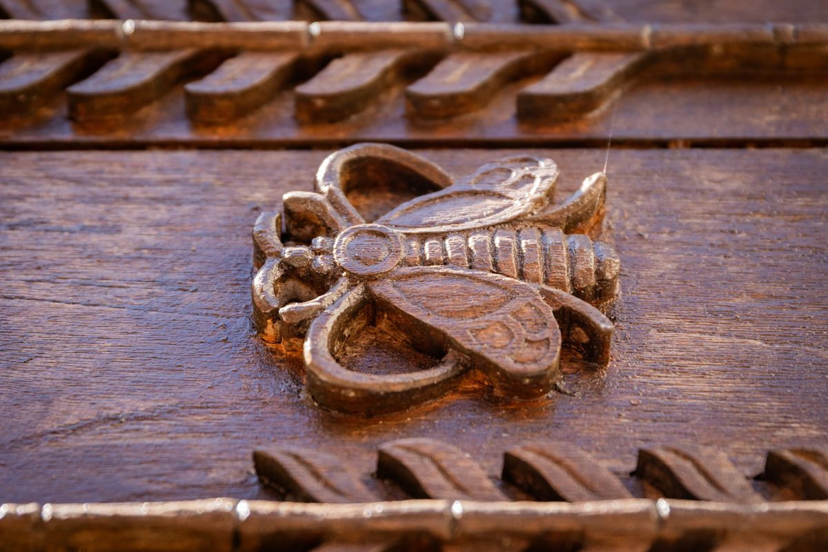 Une rosace sculptée, seule au milieu d'une poutre ancienne