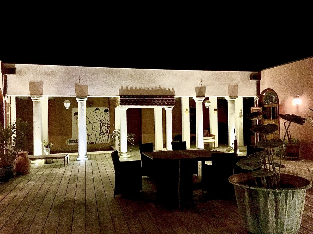 Le patio la nuit, ses colonnes éclairées et sa fresque