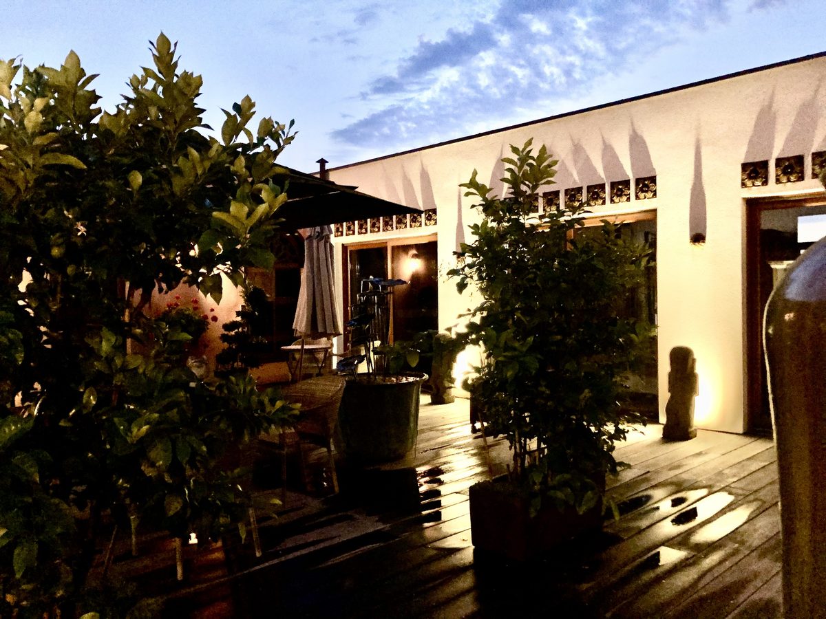 Le patio à l'heure dorée, ses agrumes en pot et ses murs chauffés par le couchant