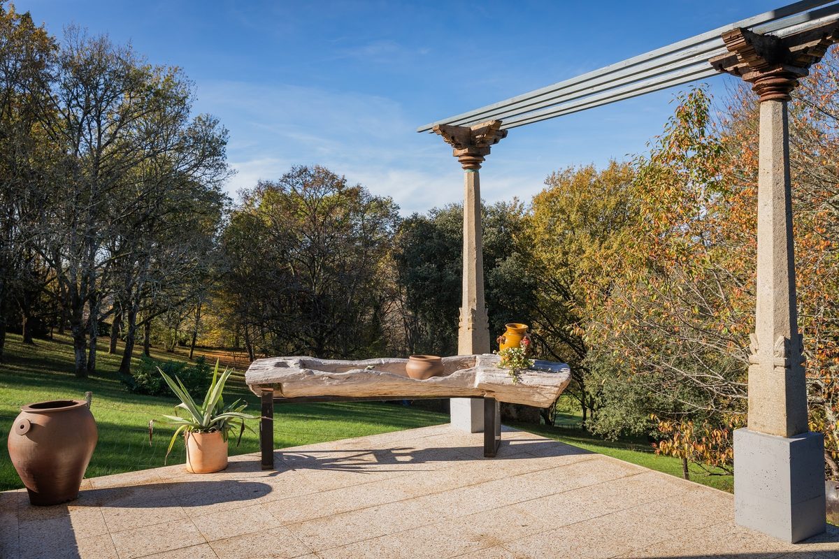 La table de granit sous la pergola, ouverte sur le parc