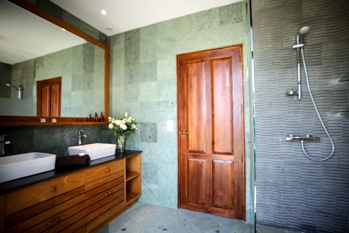 La salle de bains Granny Smith vue depuis la douche, sa cloison de pierre verte