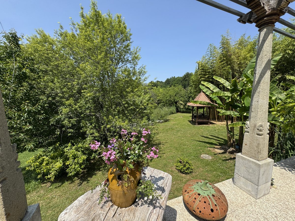 Le parc depuis la pergola, la jarre fleurie et le kiosque au fond