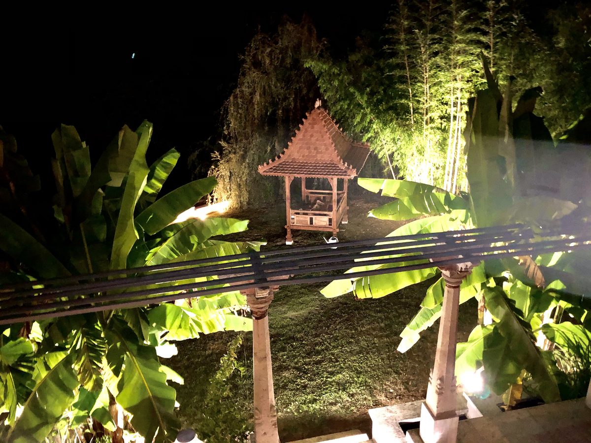 Le kiosque éclairé la nuit, sous les bananiers